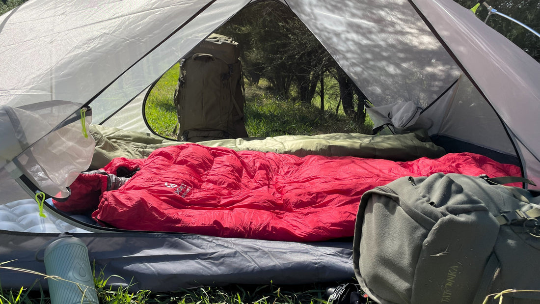Red Domex Versalite sleeping bag and camping mat set up inside Ascent tent at a New Zealand campsite. 