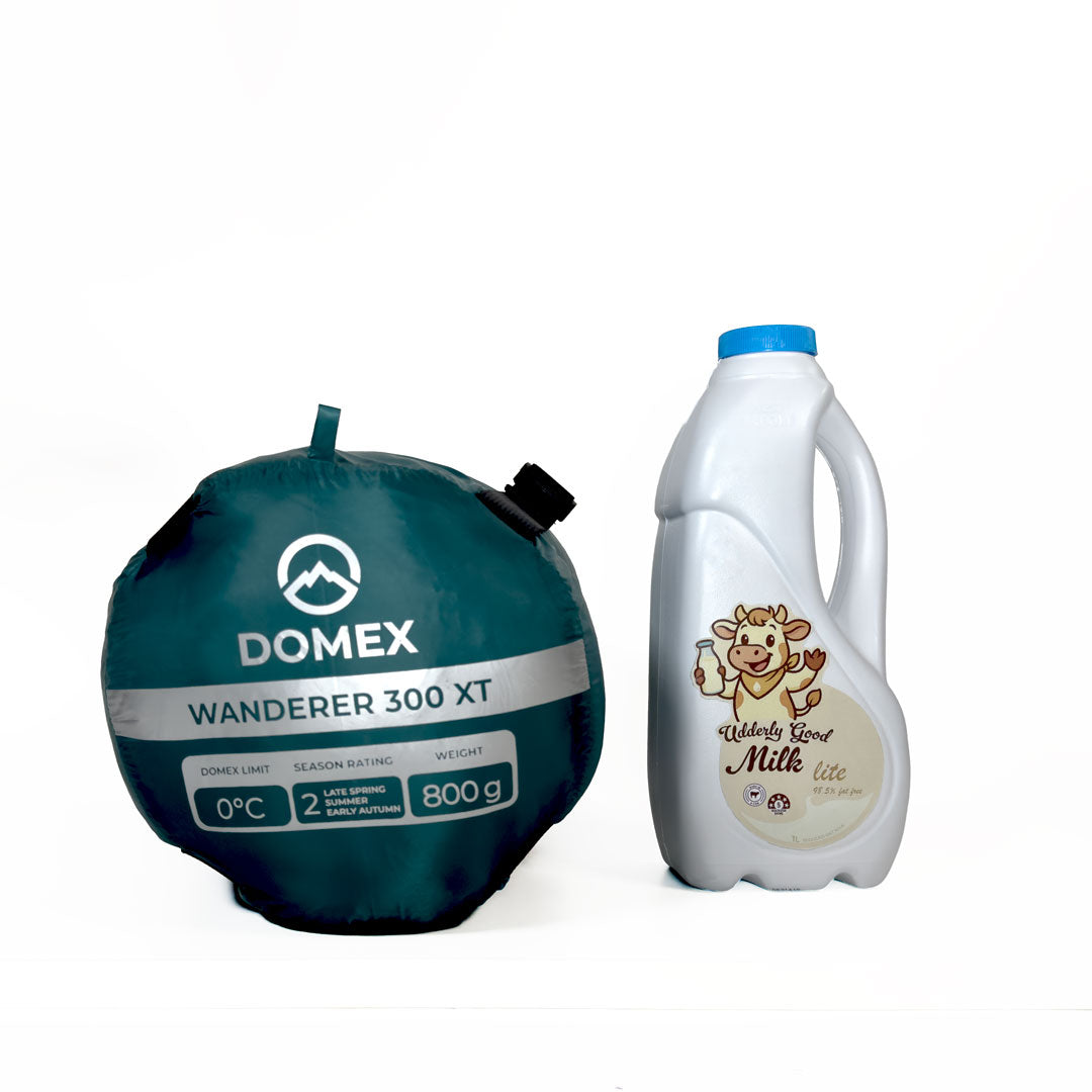 Specifications end of compression sack for Domex Wanderer 300 - 2-season down bag shown next to 1 litre bottle of milk for scale
