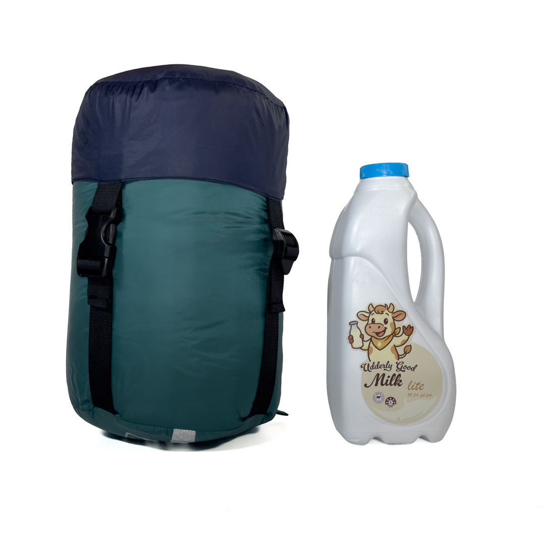 Compression sack for Domex Wanderer 300 - 2-season down bag shown on end next to 1 litre bottle of milk for scale